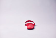 Load image into Gallery viewer, A single red slide sandal shown from the back on a clean, light gray studio background.