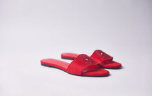 Load image into Gallery viewer, A pair of red slide sandals with open toes and rhinestone embellishments on the straps, shown on a light gray studio background.